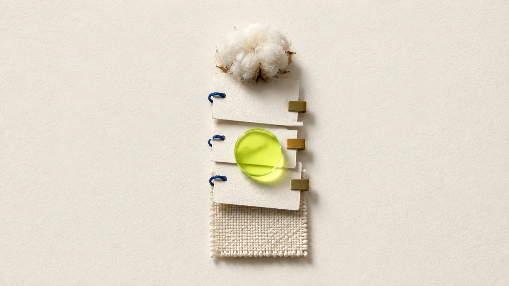 A compact stack of blank evidence cards links raw cotton to a woven swatch under a lime inspection lens.